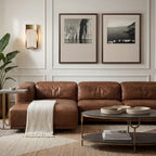 Modern living room with brown leather sofa, coffee table, and wall art.
