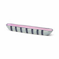 Long, narrow ceramic dish with pink and blue striped design on a white background
