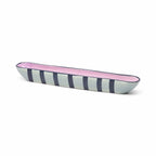 Long, narrow ceramic dish with pink and blue striped design on a white background