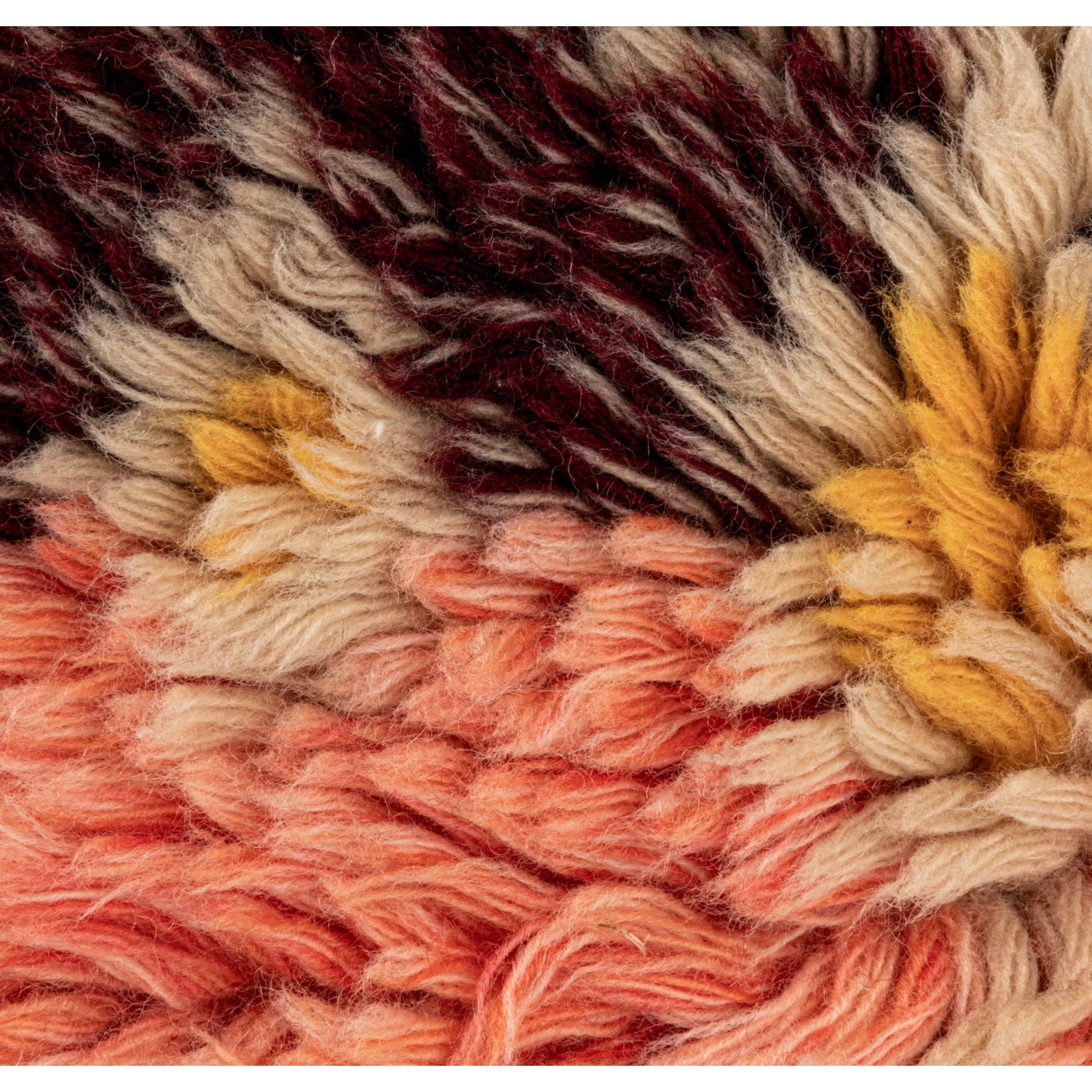 Close-up of multicolor wool shag fabric with textured fibers in orange, yellow, beige, and dark brown tones.