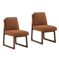 Two brown upholstered dining chairs with wooden sled-style legs and cushioned backs on white background