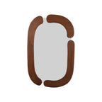 A modern oval wall mirror with a thick, rounded wooden frame in a warm medium-brown finish, shown against a plain white background.