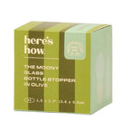 Green box packaging for 'The Moony Glass Bottle Stopper' with brand name 'here's how'.