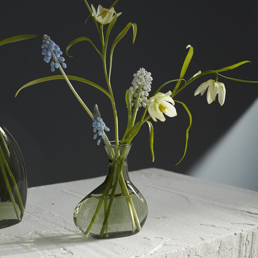 Sea glasss Vase with flowers on a textured surface