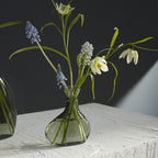 Sea glasss Vase with flowers on a textured surface
