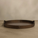 Bronze decorative tray on a beige surface with a beige background