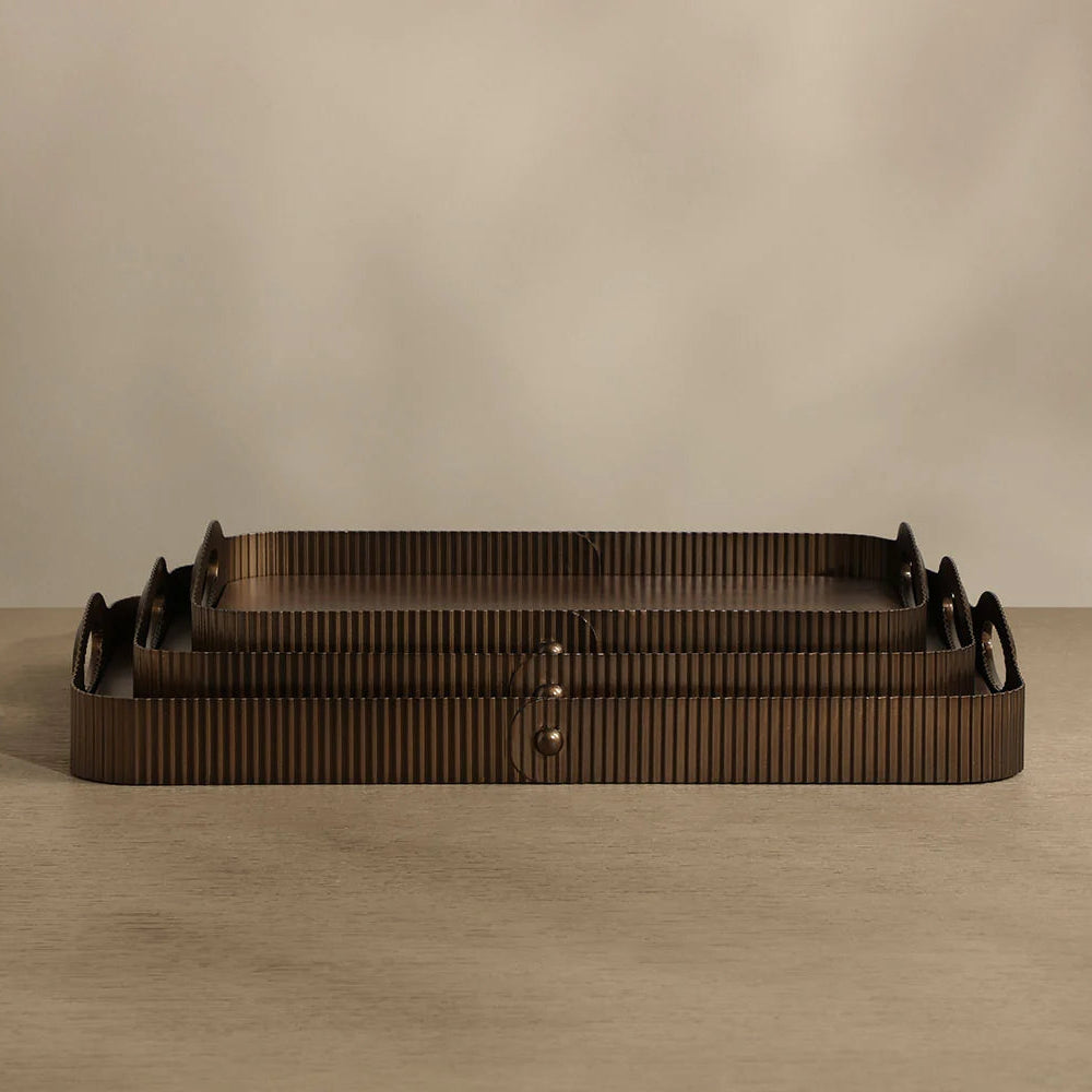 Three nested rectangular trays with a dark brown ribbed texture and integrated handles, displayed on a neutral beige surface against a matching background.