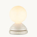 A modern table lamp with a glowing warm white spherical globe on a textured, tiered off-white base with a digital clock display showing 07:00.