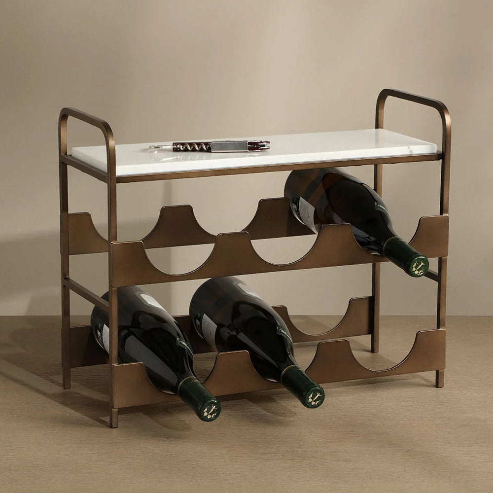 A modern wine rack with a bronze metal frame and a white marble top, shown holding three wine bottles. The background is a clean, neutral beige studio setting.